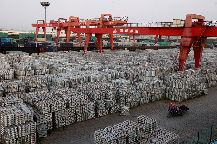 Workers seen riding on a motor rickshaw through an aluminium ingots depot in Wuxi, Jiangshu province, China - Reuters/File