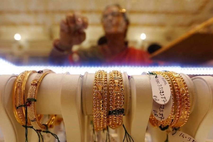 Gold bangles are on display as a woman makes choices at a jewellery showroom during Dhanteras, a Hindu festival associated with Lakshmi, the goddess of wealth, in Kolkata, India October 28, 2016. Reuters/Files