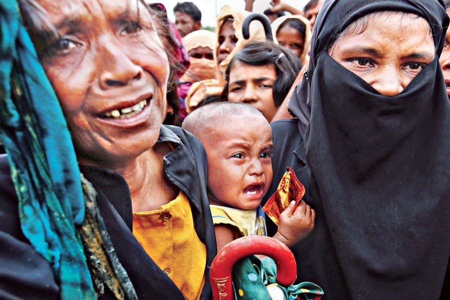 A Rohingya child weeps while its helpless refugee mother jostles for aid in Cox's Bazar in this undated file photo. Reuters