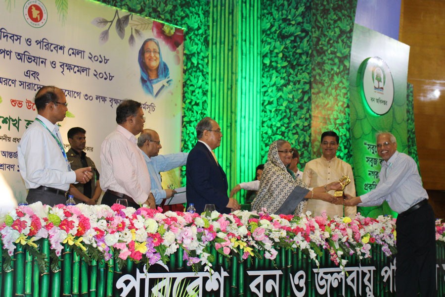 Prime Minister Sheikh Hasina is handing over the crest of “National Environment Award 2018” to Walton Group’s Vice-chairman SM Shamsul Alam at the inaugural ceremony of the “National Tree Plantation Campaign and Tree Fair 2018” at the Bangabandhu International Convention Center in the Dhaka city on Wednesday morning. Photo: Walton Group