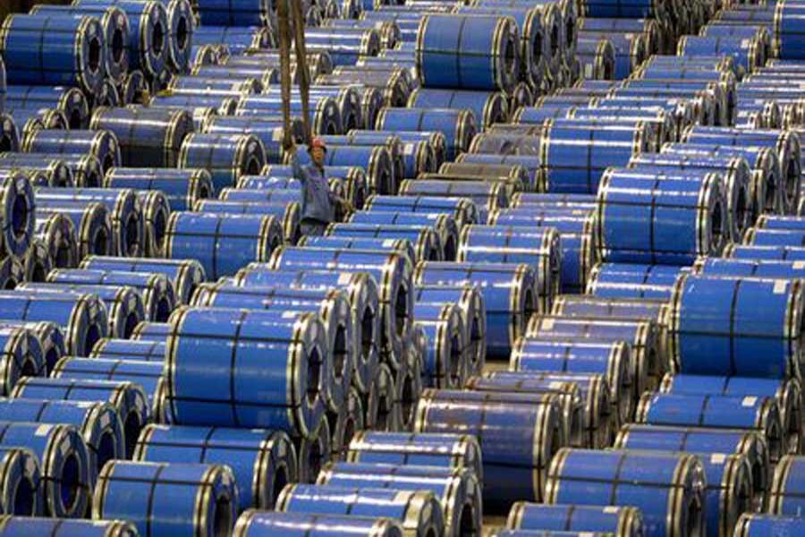 An employee works among stainless steel sheets at a steel factory in Taiyuan, Shanxi province, China, September 2, 2015. Reuters/File Photo