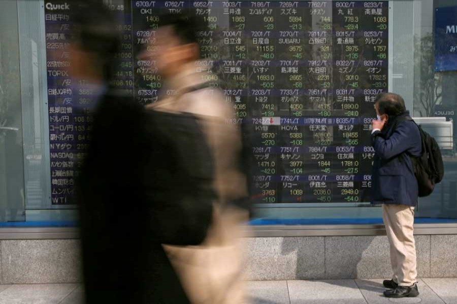 A man looks at an electronic stock quotation board outside a brokerage in Tokyo, Japan February 9, 2018. Reuters/Files