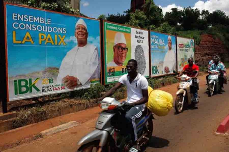People ride their motorcycle past electoral billboards of Ibrahim Boubacar Keita, the Malian president and leader of RPM (Rassemblement Pour le Mali) in Bamako, Mali on July 23. Reuters photo