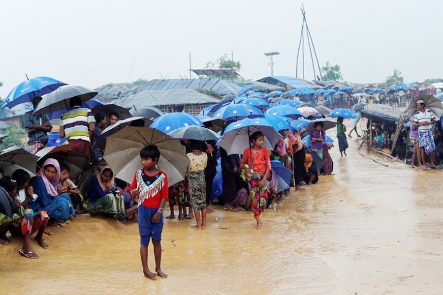 Rohingya refugees queue in the rain to receive food at Kotupalang refugee camp near Cox's Bazar recently	— Reuters