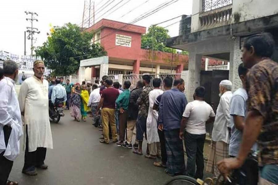 People stand in queue for casting vote in Sylhet city corporation election at a centre on Monday. Photo: UNB