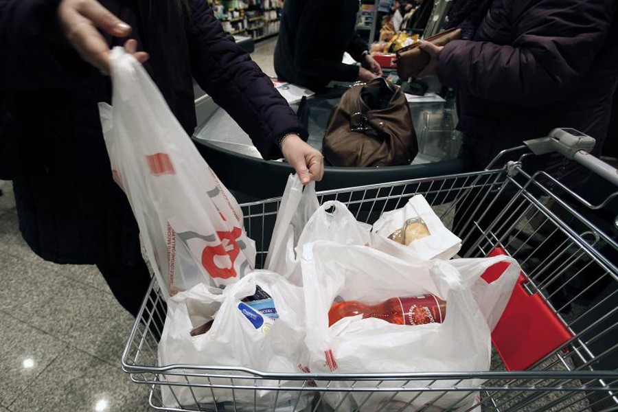 Customers place their plastic shopping bags in a trolley after shopping in a supermarket in Rome December 29, 2010 – Reuters photo used for representation