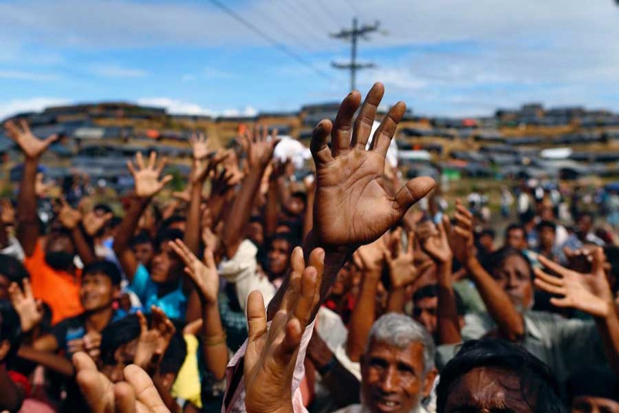 Rohingya refugees stretch their hands to receive aid distributed by local organisations at Balukhali makeshift refugee camp in Cox's Bazar, Bangladesh, September 14, 2017. Reuters/Files