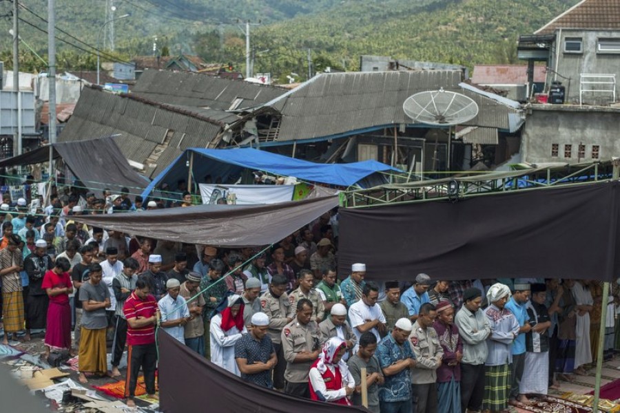 Muslim men perform Friday prayer as houses ruined by Sunday’s earthquake are seen in the background at a makeshift mosque in Pamenang, Lombok Island, Indonesia, Friday, Aug. 10, 2018. The north of the popular resort island has been devastated by Sunday’s earthquake, damaging thousands of buildings and killing a large number of people. – AP photo