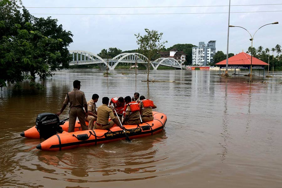 Rescue personnel patrolling the flooded waters on the banks of Periyar River after the opening of Idamalayar and Cheruthoni dam shutters following heavy rains, on the outskirts of Kochi on Friday. -Reuters Photo