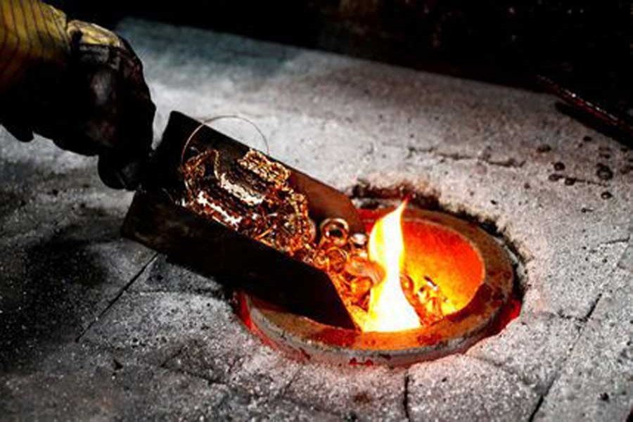 A worker places gold jewellery into a melting furnace at the Austrian Gold and Silver Separating Plant 'Oegussa' in Vienna, Austria, December 15, 2017. Reuters/File Photo