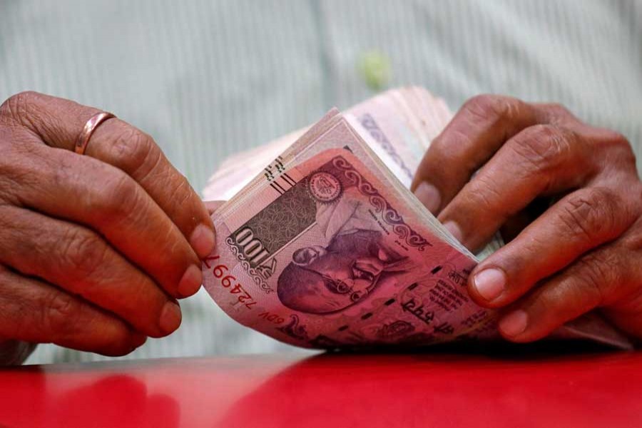 A man counts Indian currency notes inside a shop in Mumbai, India, August 13, 2018. Reuters/File photo