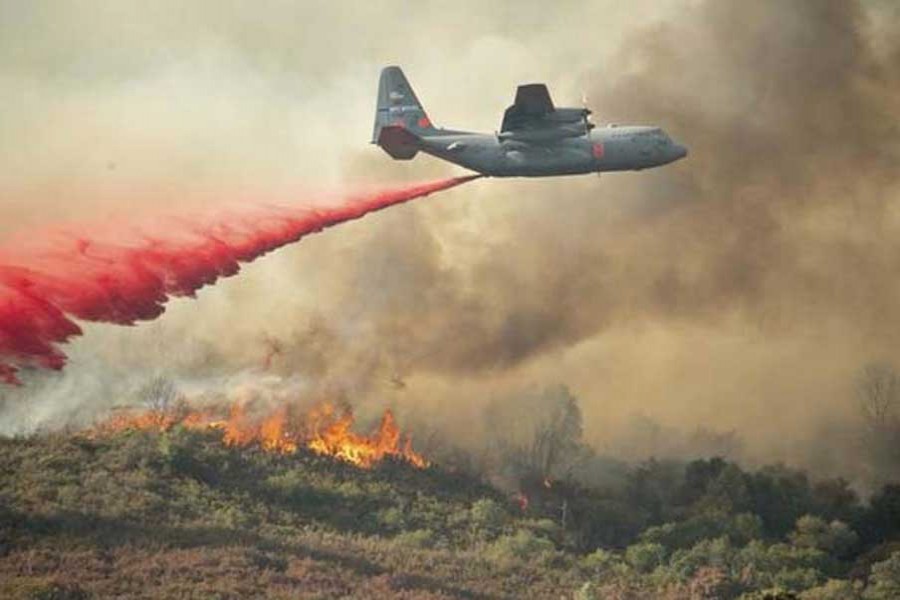 A US Air Force plane drops fire retardant on a burning hillside in the Ranch Fire in Clearlake Oaks, California, on August 05, 2018. - AP