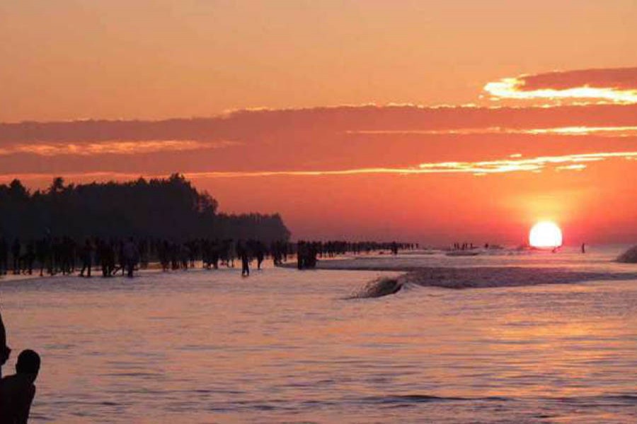 Tourists enjoy sunset over a Kuakata beach