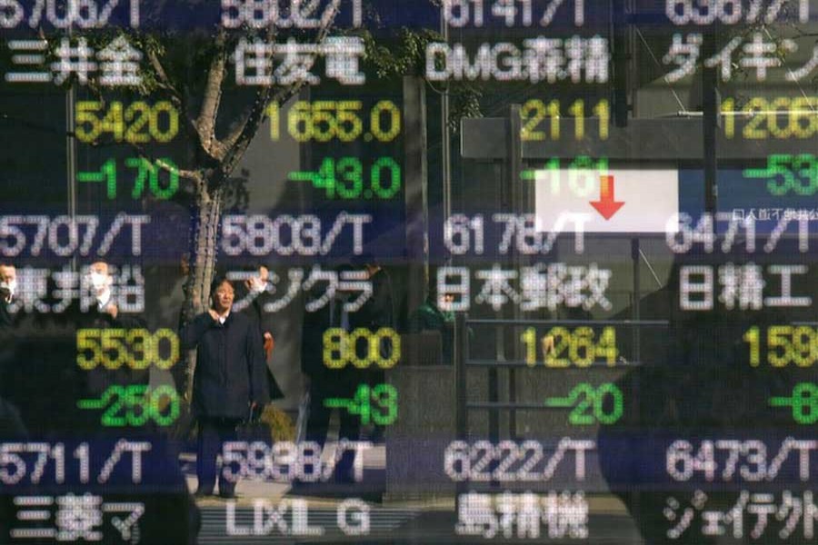 A man is reflected in an electronic stock quotation board outside a brokerage in Tokyo, Japan February 9, 2018. Reuters/Files