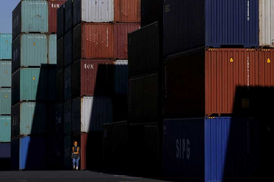 A worker walks in a container area at a port in Tokyo, Japan January 25, 2016. Reuters/Files