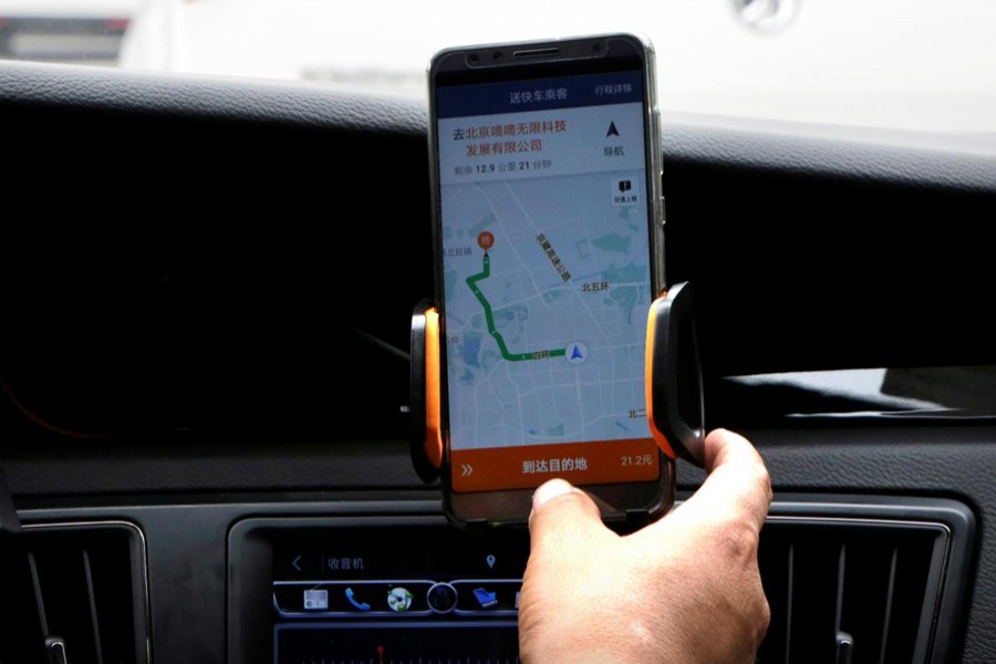 A Didi Chuxing driver checks the information on the application in his car in Beijing, China August 28, 2018. Reuters photo