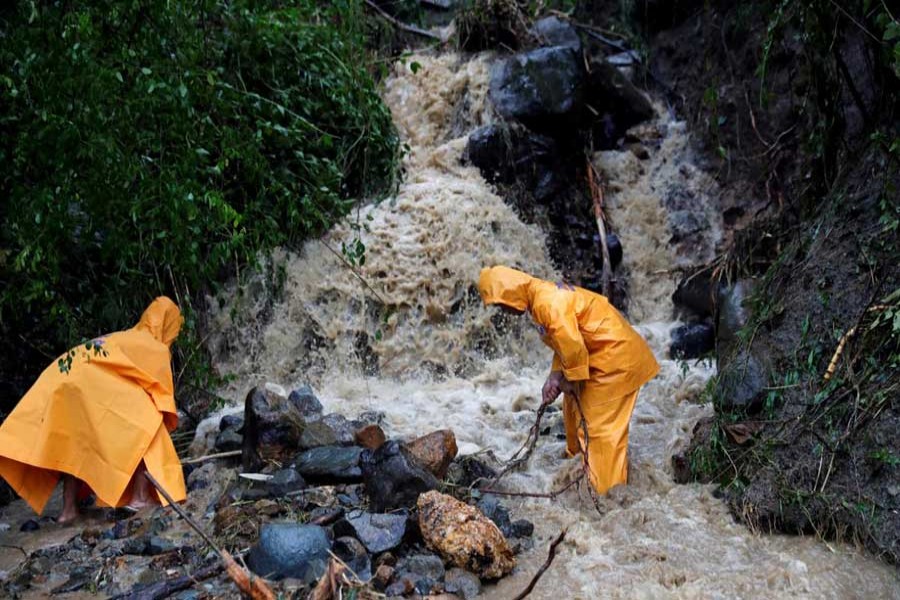 Government workers clear a partially damaged road after Typhoon Mangkhut hit the main island of Luzon, in Sta Fe, Nueva Viscaya, Philippines, September 15, 2018. Reuters