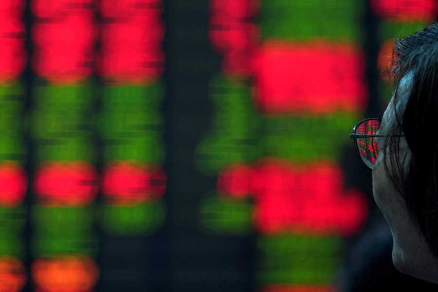 An investor looks at an electronic board showing stock information at a brokerage house in Shanghai, China, July 6, 2018. Reuters/File Photo