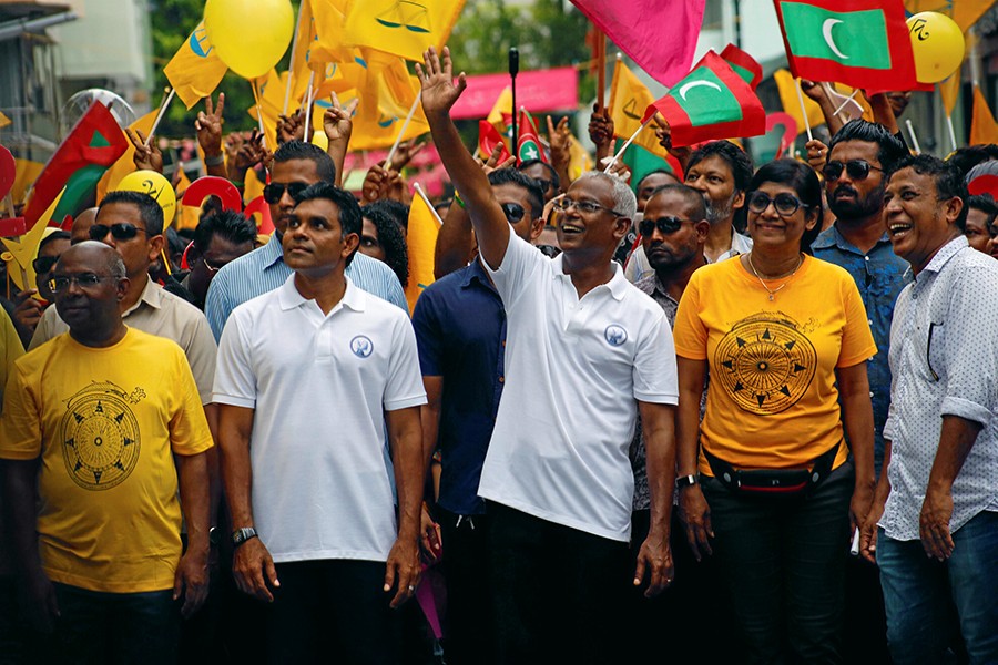 Ibrahim Mohamed Solih, Maldivian presidential candidate backed by the opposition coalition, waves as he stands next to his supporters during the final campaign rally ahead of the election in Male, Maldives on Saturday — Reuters/File