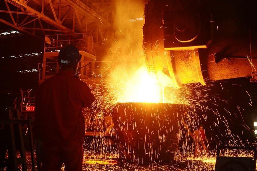 An employee works next to molten iron at a steel mill in Dalian, Liaoning province, China, July 17, 2018. Reuters/Files