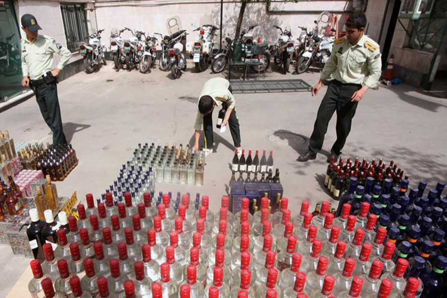 Iranian police prepare to destroy confiscated bottles of spirits in Tehran. Alcohol has been banned in the country since the 1979 Islamic Revolution — Collected