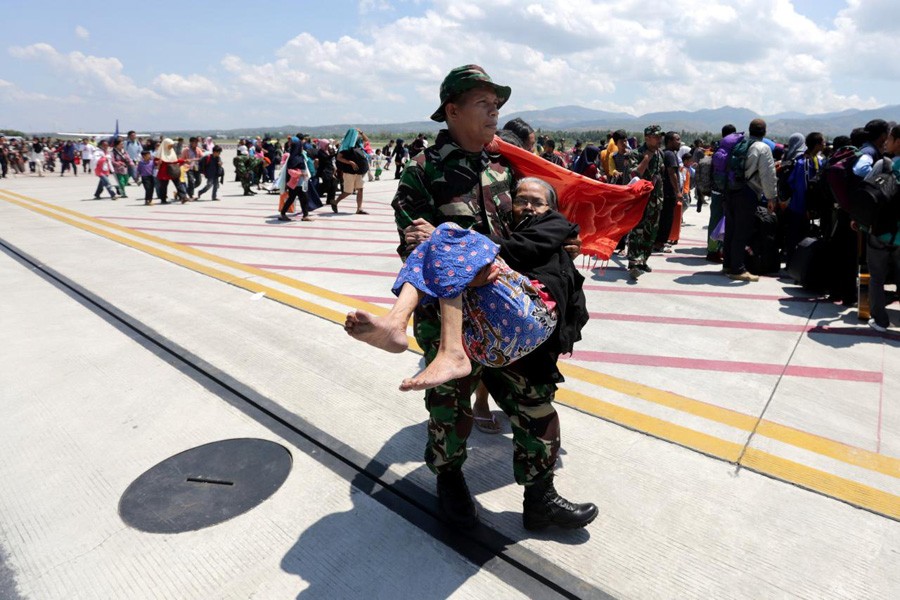 An Indonesian soldier carries an elderly woman evacuated after an earthquake and tsunami at Mutiara Sis Al Jufri airport in Palu, Central Sulawesi, Indonesia, October 1, 2018 in this photo taken by Antara Foto. Reuters