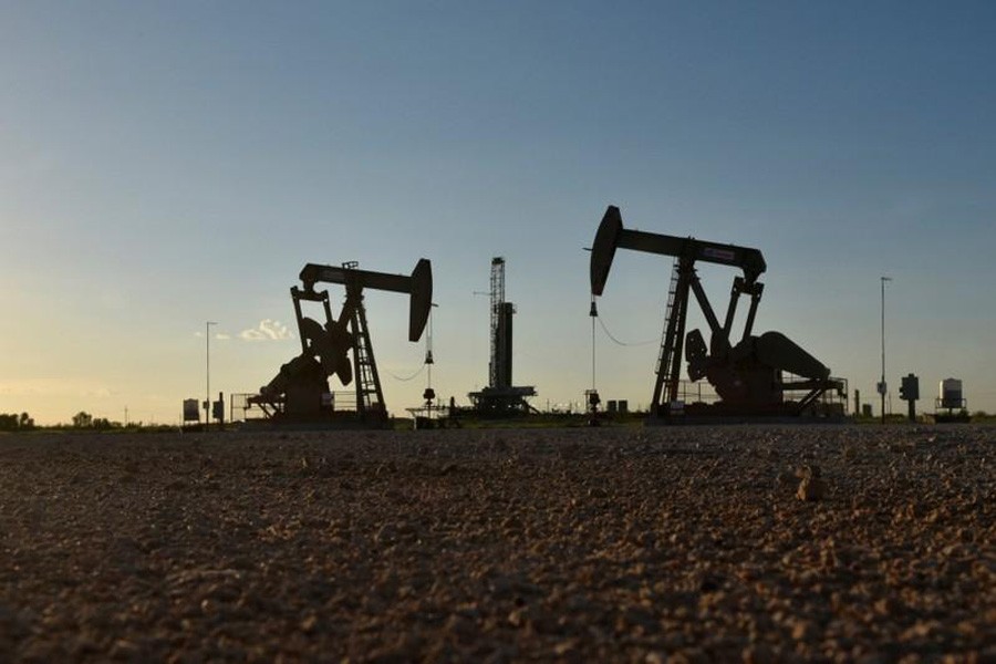 Pump jacks operate in front of a drilling rig in an oil field in Midland, Texas, US, August 22, 2018. Reuters/File Photo