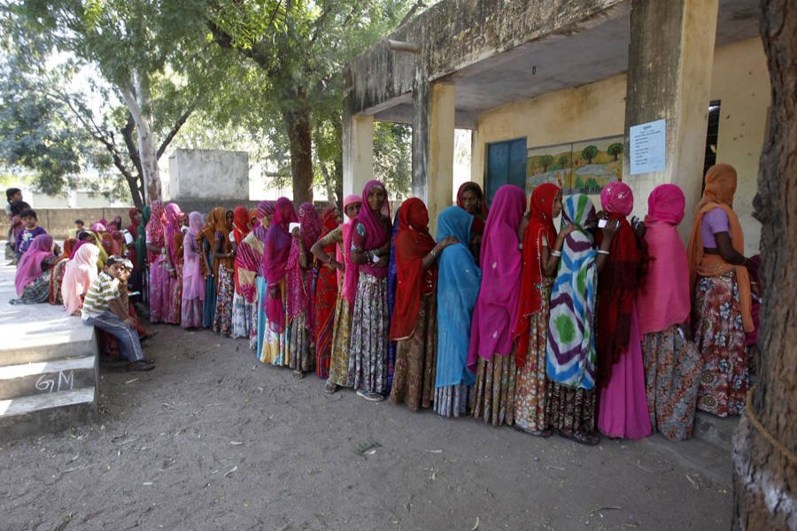 Voters line up in a queue outside a polling booth to cast their vote during the state assembly election in Maval town, located in Rajasthan, December 1, 2013. Reuters/Files