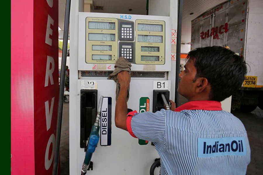 A worker cleans a pump at a fuel station in Ahmedabad, India, May 14, 2018. Reuters/File Photo