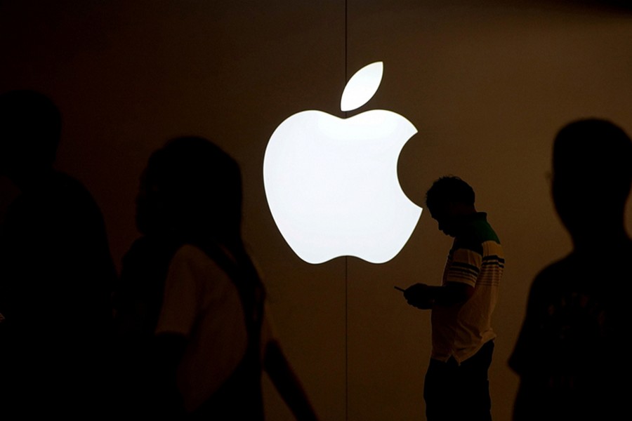 A man looks at the screen of his mobile phone in front of an Apple logo outside its store in Shanghai, China on July 30, 2017 — Reuters/File