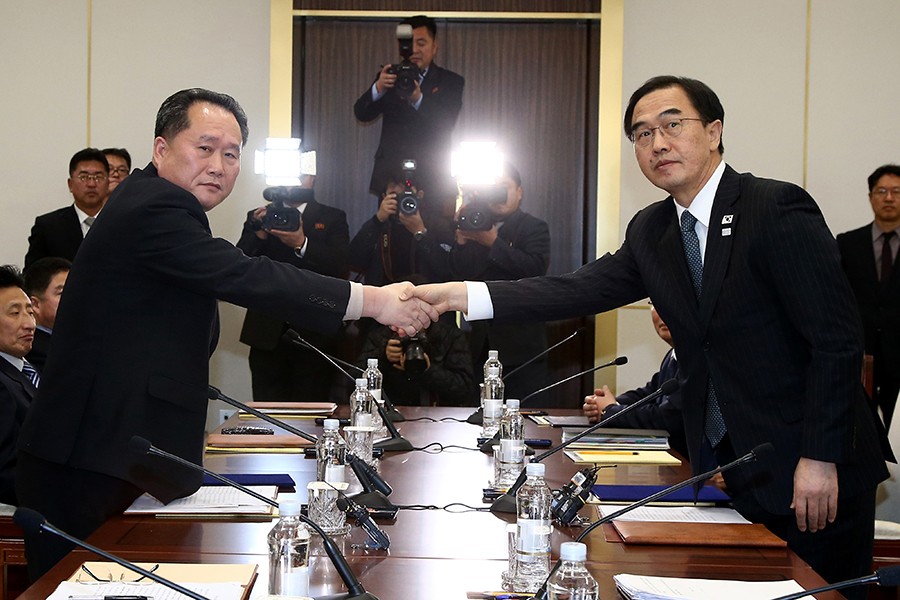 Head of the North Korean delegation, Ri Son Gwon shakes hands with South Korean counterpart Cho Myoung-gyon as they exchange documents after their meeting at the truce village of Panmunjom in the demilitarised zone separating the two Koreas on January 9, 2018 — Reuters/File