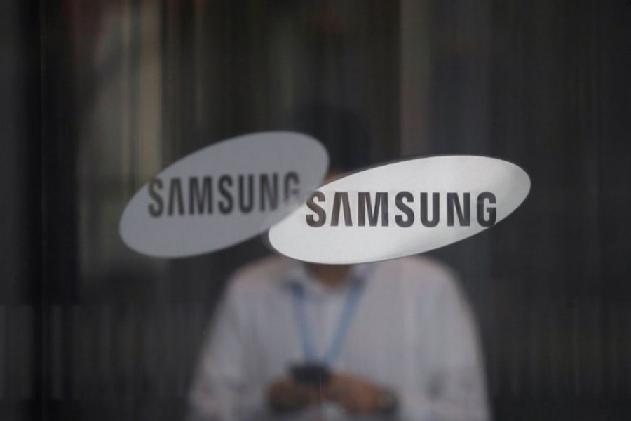 An employee using his mobile phone walks past the logo of Samsung Electronics at its office building in Seoul, South Korea on August 25, 2017 — Reuters/File