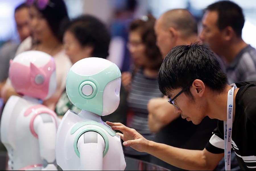 A man programs an iPal Companion Robot by Nanjing Avatar Mind Robot Technology at the 2017 World Robot conference in Beijing, on August 22, 2017 — Reuters/File