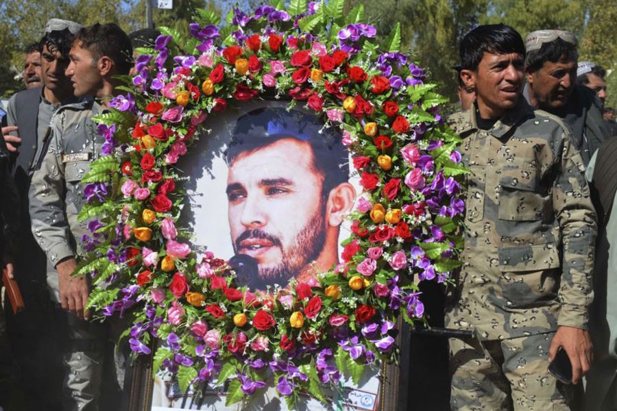 Military personnel held a photo of Gen Abdul Raziq, Kandahar police chief, who was killed by a guard, during his burial ceremony in Kandahar, Afghanistan, Oct 19, 2018 – AP photo