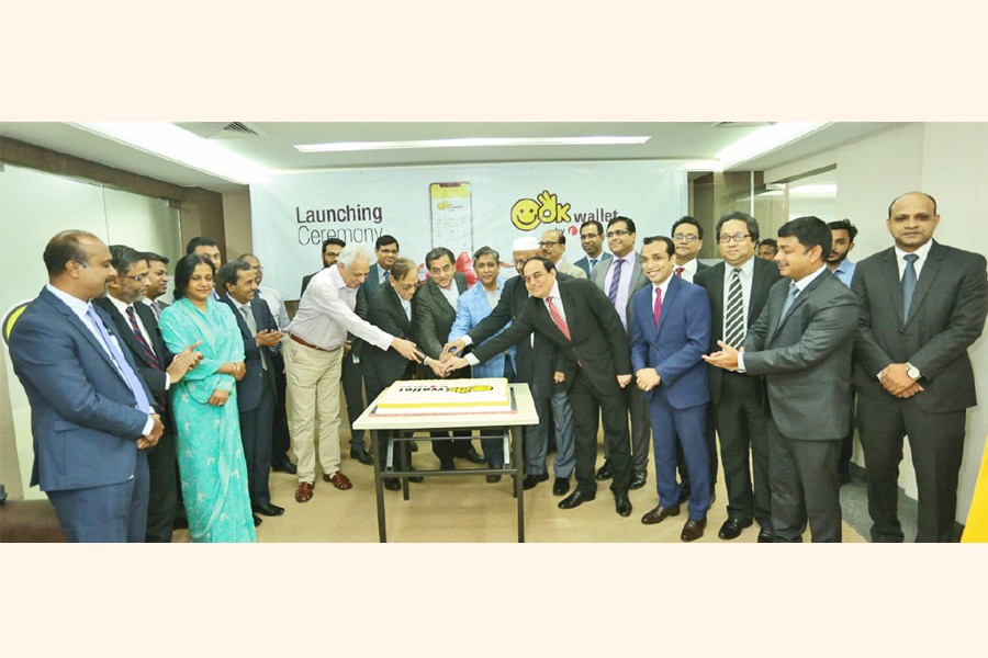 Chairman of the board of directors of ONE Bank Limited Sayeed H Chowdhury inaugurating the OK wallet service through a cake cutting ceremony at OBL Corporate Headquarters in the city on Tuesday. ONE Bank Ltd Vice Chairman Ashok Das Gupta, Executive Committee Chairman Zahur Ullah, directors Shawket Jaman, Salahuddin Ahmed and Syed Nurul Amin, and Managing Director M Fakhrul Alam, were present on the occasion