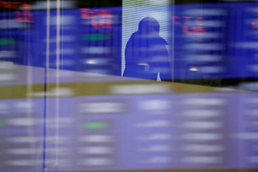 Visitors are seen as market prices are reflected in a glass window at the Tokyo Stock Exchange (TSE) in Tokyo, Japan, October 1, 2018. Reuters/Files