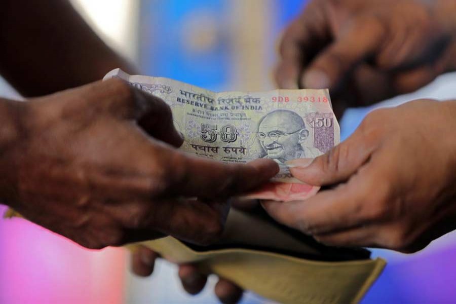 A customer hands a 50-Indian rupee note to an attendant at a fuel station in Ahmedabad, India, October 5, 2018. Reuters