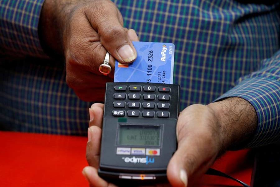 A shopkeeper swipes a customer's debit card with the logo of RuPay at an electronics goods store in Kolkata, October 31, 2018. Reuters