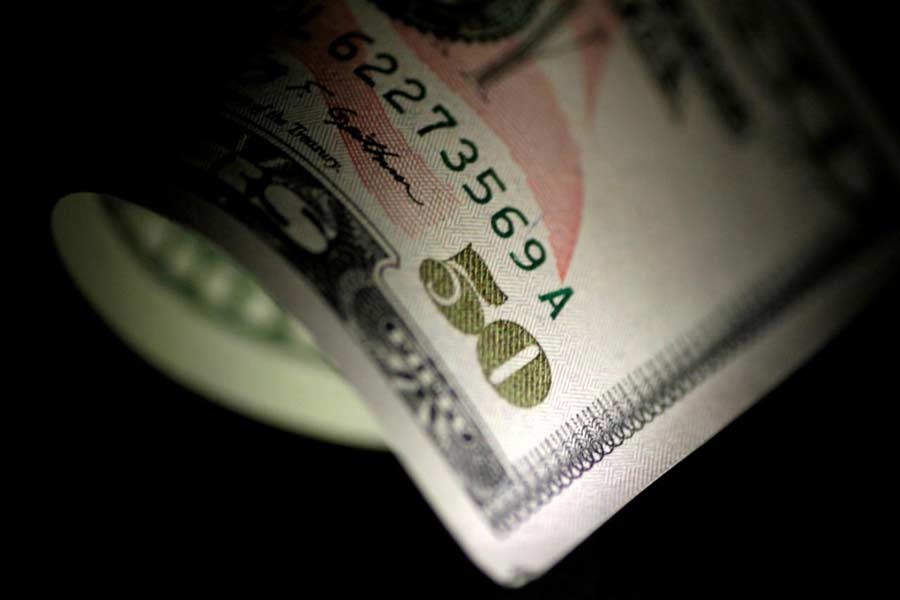 An employee counts US dollars next to yuan banknotes at a bank in Hefei, Anhui province in this September 21, 2010 file photograph. Reuters/Stringer/Files