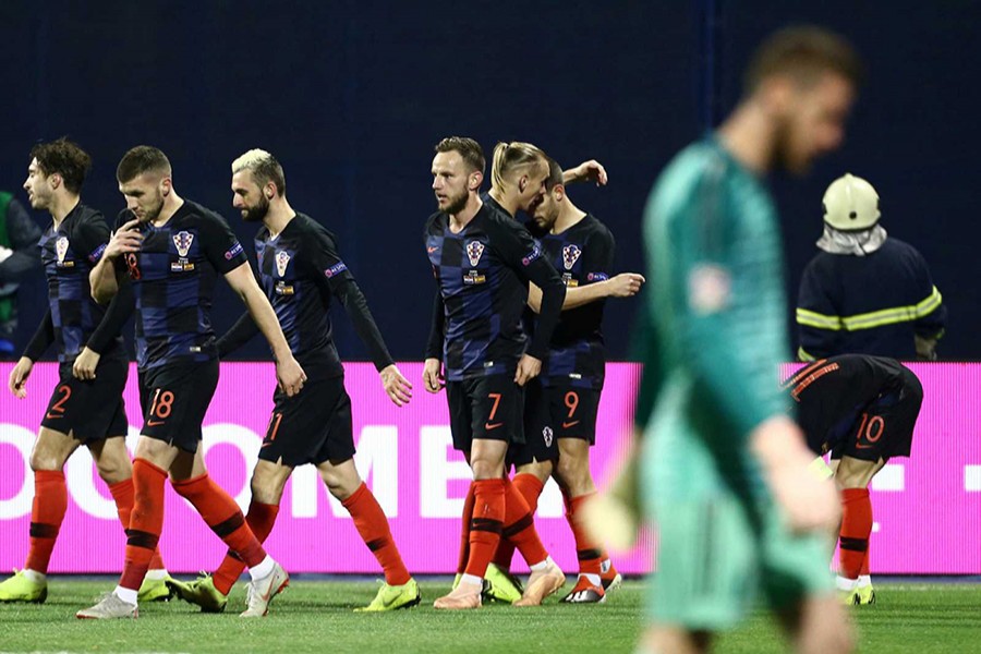 Croatia's Andrej Kramaric (left) celebrates scoring their first goal with teammates while Spain's goalie De Gea cuts a dejected figure — Reuters photo