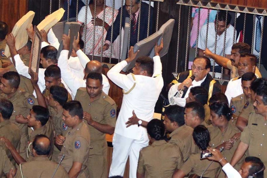 A Parliament Member, who is backing newly appointed Prime Minister Mahinda Rajapaksa, throws a chair at police who are there to protect parliament speaker Karu Jayasuriya (not pictured) during a parliament session in Colombo, Sri Lanka on November 16, 2018.  	—Photo: Reuters