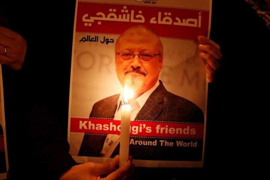 A demonstrator holds a poster with a picture of Saudi journalist Jamal Khashoggi outside the Saudi Arabia consulate in Istanbul, Turkey October 25, 2018 - Reuters