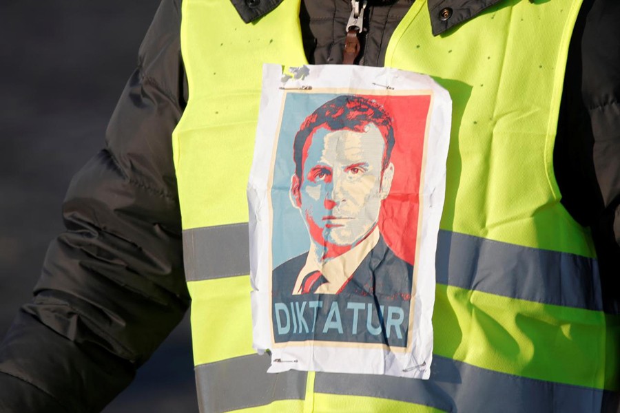 A man wearing a yellow vest, a symbol of a French drivers' protest against higher fuel prices, attends the demonstration with an image of French president Emmanuel Macron, in Paris, France, November 17, 2018. Reuters