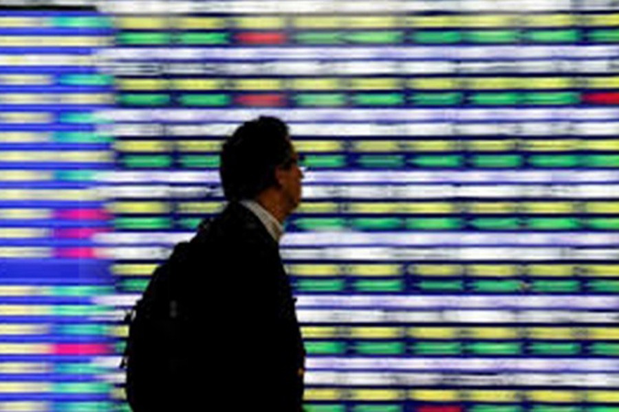 A man walks past an electronic stock quotation board outside a brokerage in Tokyo, Japan, November 13, 2018. Reuters/Files
