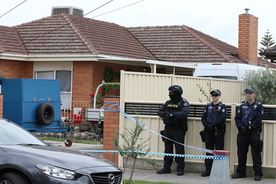 Police officers stand outside a home they raided on Tuesday as part of an operation in which they arrested three men who were allegedly preparing to attack the public in Melbourne, Australia — Reuters photo