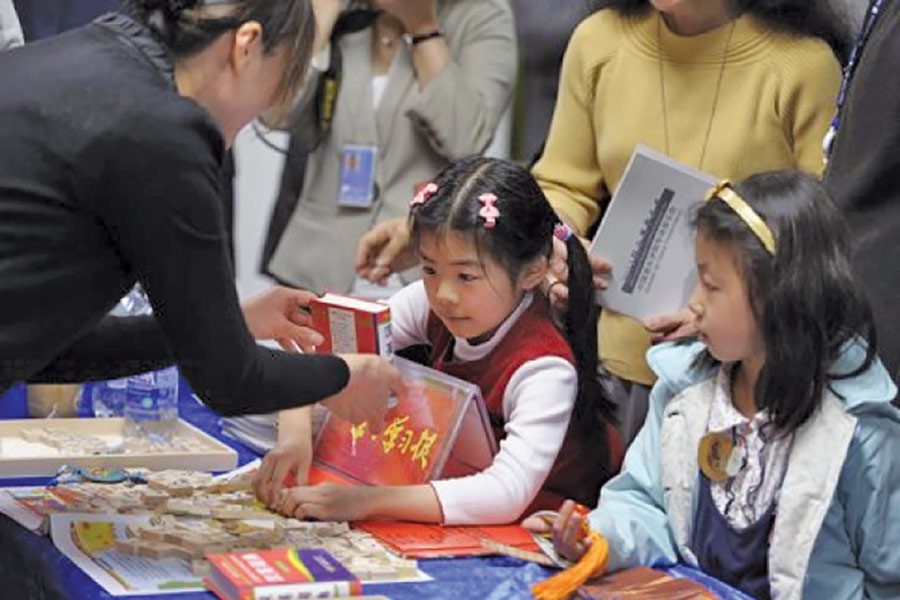 Children participate in UN Headquarters' celebration of Chinese Language Day on April 20, 2018, where books and games were on offer.         —Photo: Xinhua