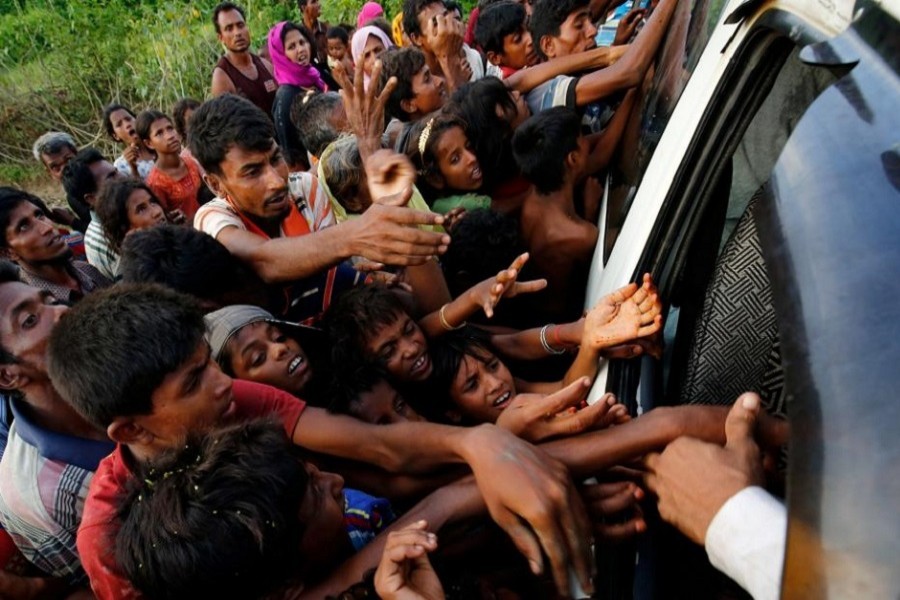 Rohingya refugees stretch their hands for food near Balukhali in Cox's Bazar, Bangladesh, September 4, 2017. Reuters/Files