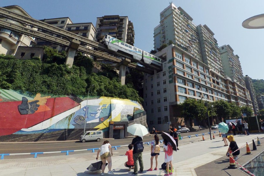 People take pictures of a Chongqing Rail Transit train whose train track passes through a residential building, in Chongqing, China on August 21, 2018 — Reuters photo