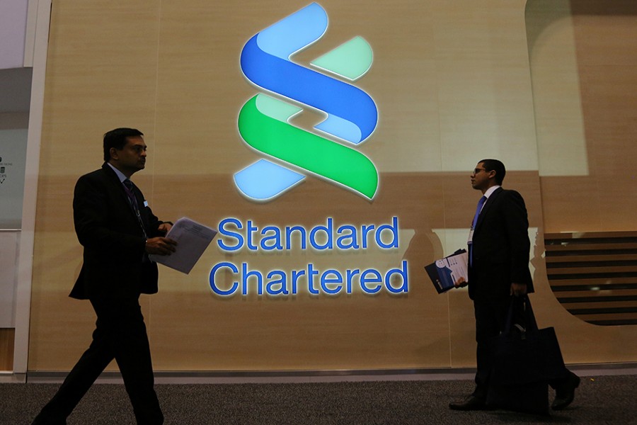 People pass by the logo of Standard Chartered at the SIBOS banking and financial conference in Toronto, Ontario, Canada on October 19, 2017 — Reuters/File