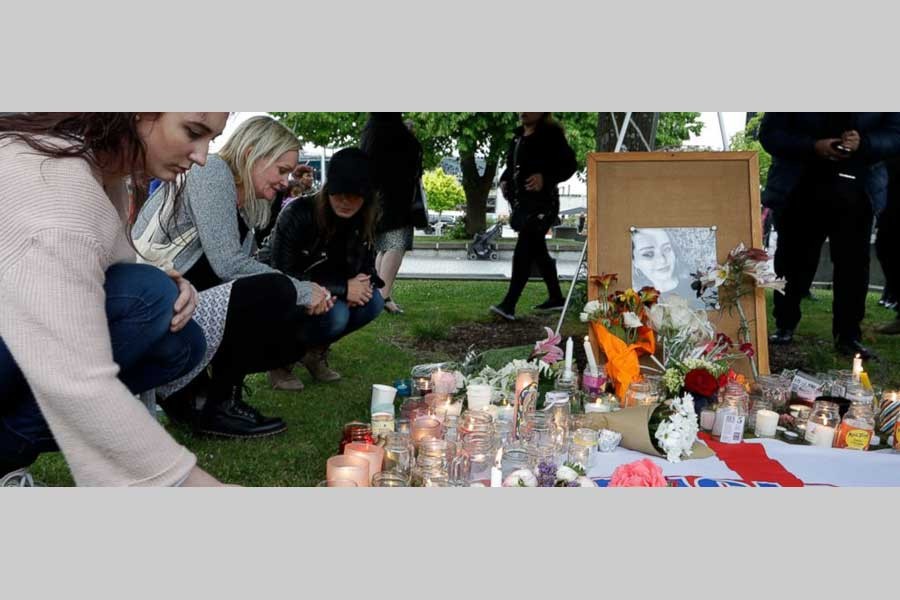 People lay flowers and light candles during a candlelight vigil for murdered British tourist Grace Millane at Cathedral Square in Christchurch, New Zealand, Wednesday, Dec. 12, 2018. - AP Photo